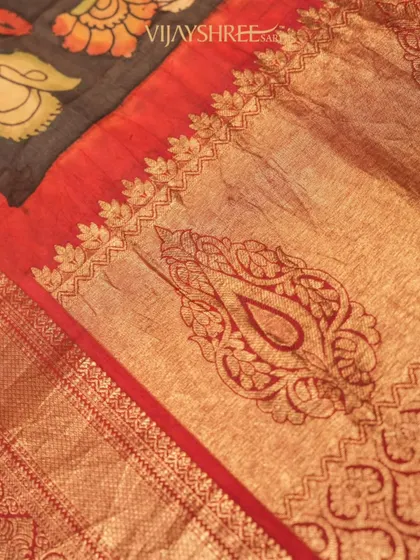 A close-up of the Kalamkari pallu, where the intricate paisley and floral designs are highlighted against the rich gold zari.