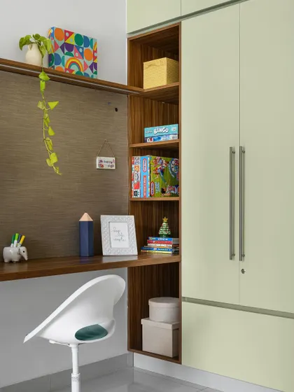The study area in the 'Poorna' kids' room seamlessly transitions into a wardrobe, with open shelving for books and toys.