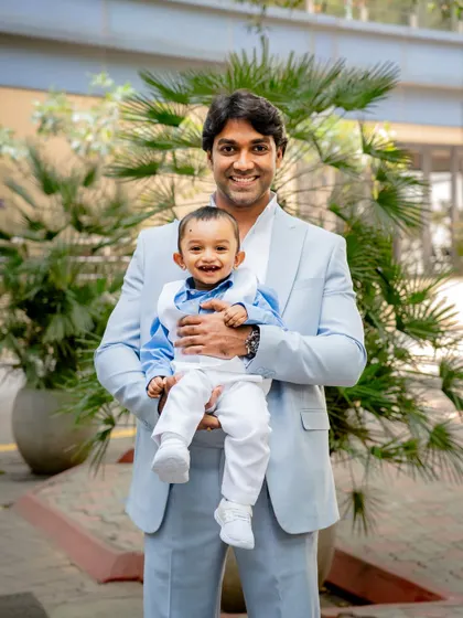 A proud father holds his smiling son during a family event. We capture both posed and candid portraits to give you a complete collection of memories.