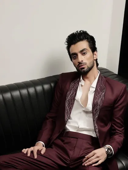 This burgundy tuxedo features an intricately embroidered shawl lapel, offering a unique and artistic take on formal wear. It's designed for making a memorable entrance.