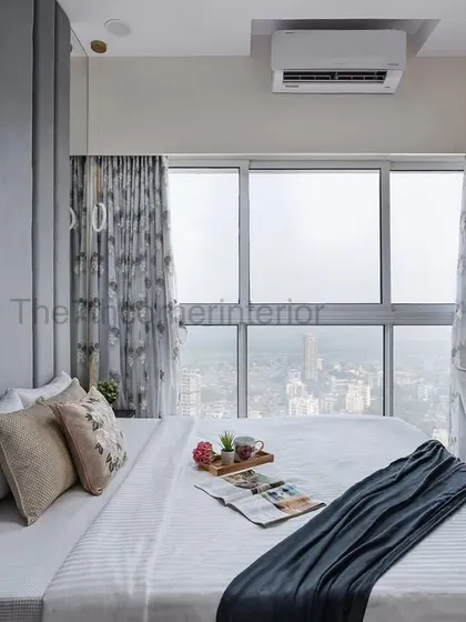 A serene bedroom from the 'Royal Mansion' project, featuring a floor-to-ceiling upholstered headboard and an integrated study desk, all designed to maximize comfort while enjoying the stunning city view.
