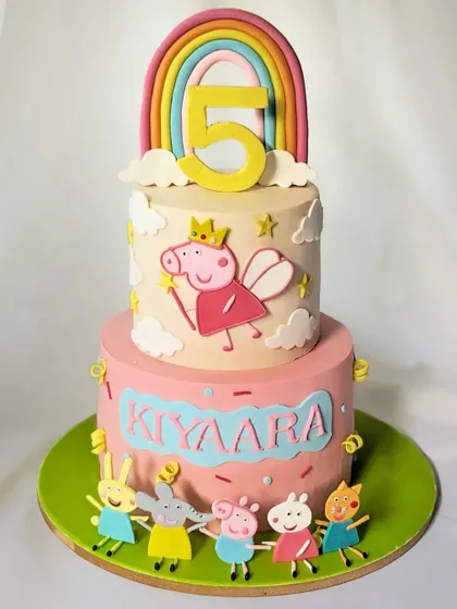 A fairy Peppa Pig cake for a magical 5th birthday. This two-tier cake features Peppa as a fairy princess, surrounded by her friends and a rainbow.