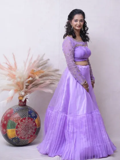 A lovely lavender lehenga with a pleated skirt and sheer embroidered sleeves. A great choice for bridesmaids or wedding guests.