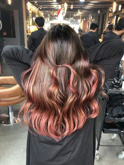 A half-up style showing off the beautiful blend of caramel, mocha, and plum in this triple-tone balayage.