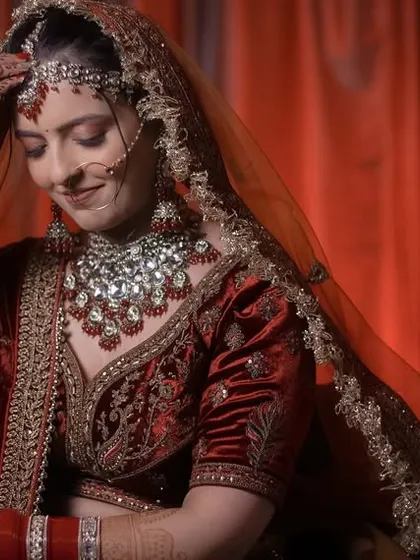 A candid moment of a bride adjusting her maang tikka, her gentle smile captured perfectly.