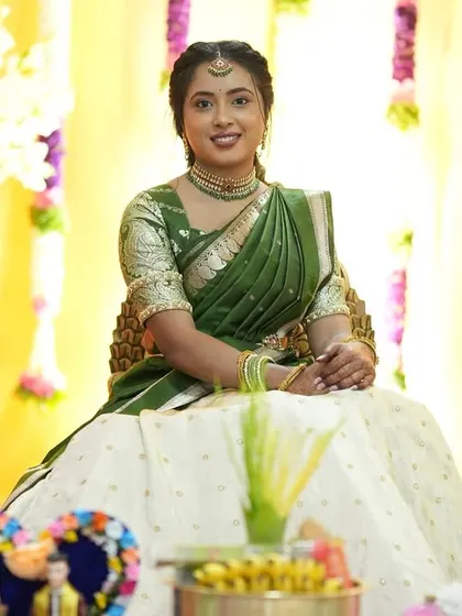 Seated amidst beautiful floral decor, her makeup remains the star. The dewy finish on her skin catches the light perfectly, giving her an ethereal glow.