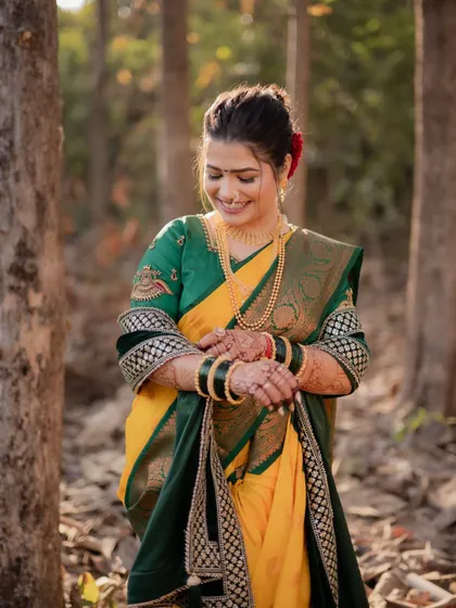 A lovely portrait of the bride looking down with a gentle smile, her hands clasped, in a beautiful forest setting.