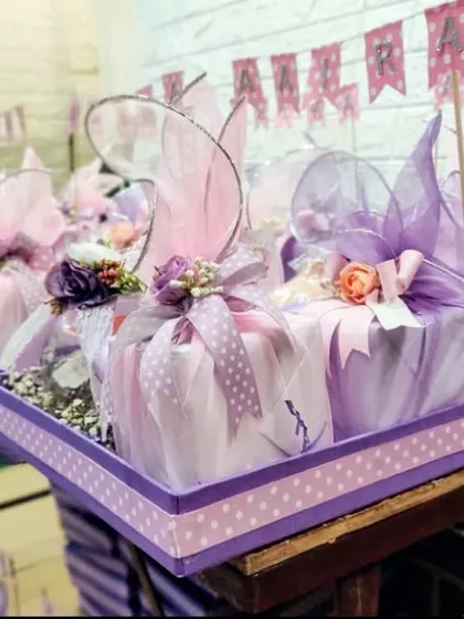 A closer look at the mauve and pink themed baby girl announcement hampers. The mix of polka dots, florals, and delicate fabrics creates a soft and celebratory feel.