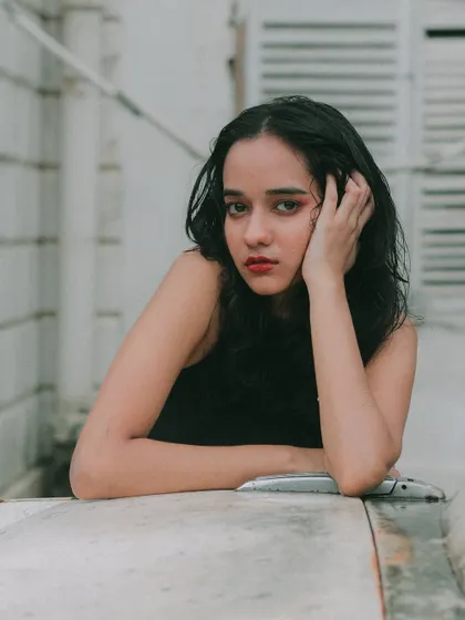 A thoughtful, intimate portrait. The soft focus and the model's expression create a feeling of vulnerability and beauty.