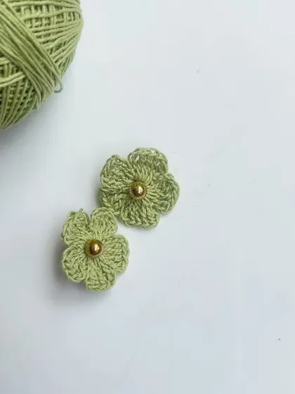 A close-up of the floral stud earrings. The golden bead center adds a little bit of sparkle.