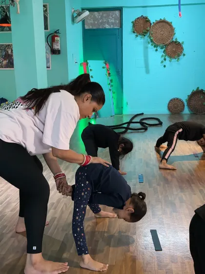 A deep forward bend with assistance. I help students safely explore their range of motion and push their flexibility boundaries.