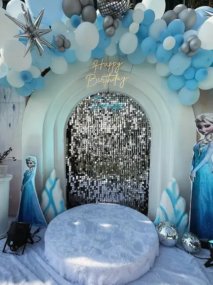 Let it go, let it go! I created a winter wonderland for a 'Frozen' themed party, complete with a sparkling sequin backdrop, character cutouts of Elsa and Olaf, and faux snow for a truly immersive Arendelle experience.