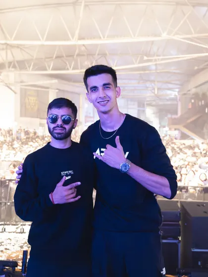 On stage with a fellow DJ, with the huge concert audience visible behind us. This highlights my experience as a collaborative performer on a large stage.