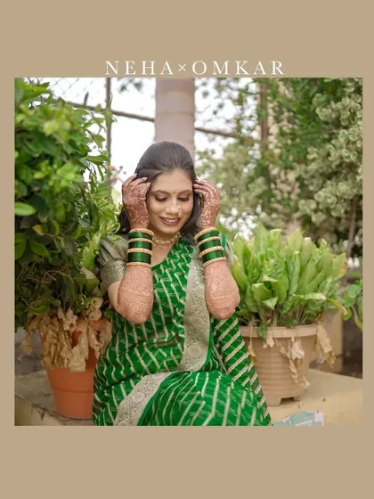 A beautiful candid shot of a bride in a traditional green saree, a significant color in Maharashtrian weddings. Her happy expression captures the joy of the day.