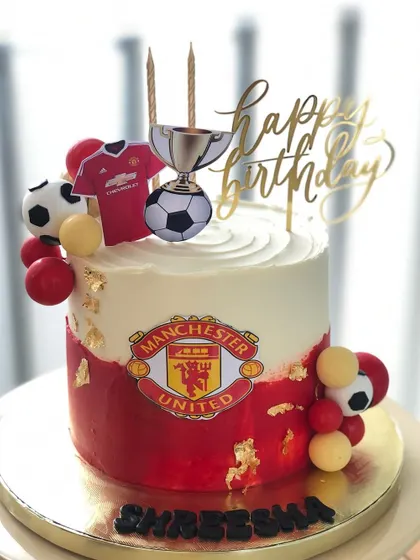 A Manchester United-themed cake for a dedicated fan, featuring the club's logo and colors.