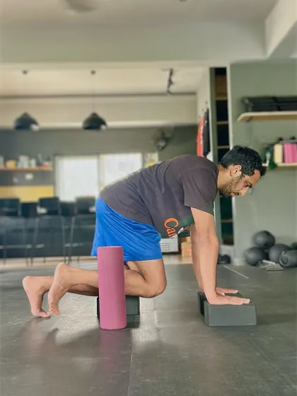 The starting position for a hip CAR requires a stable core and a flat back. Using yoga blocks helps maintain proper alignment, ensuring the movement comes purely from the hip joint for maximum benefit.