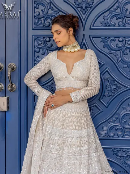 A closer look at the ivory lehenga, highlighting the fine mirror work, intricate sequins, and linear embroidery that celebrate both boldness and beauty.