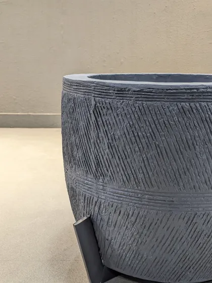 A detailed shot of the texture on our dark grey planter. The carved diagonal lines give it a unique, handcrafted feel that adds character to any plant arrangement.