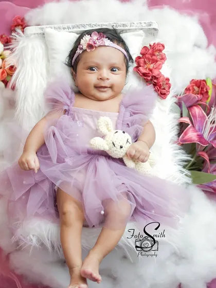 Another angle of this dreamy purple-themed newborn shoot. The combination of textures, from the fluffy clouds to the tulle dress, adds depth and beauty to the image.