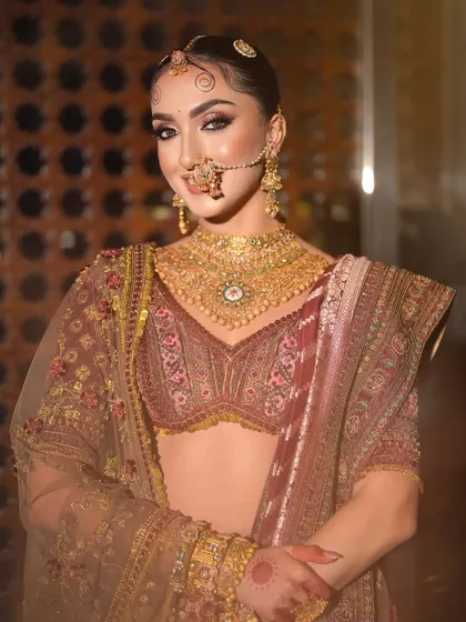 A vision dipped in royalty. This majestic and timeless Indian bridal look features soft, blended eyeshadow, intricate hair details, and stunning gold jewellery.