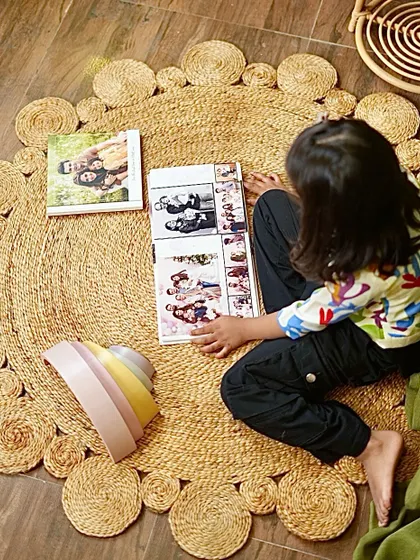 My daughter looking through photo albums on her own. An accessible and inviting floor space encourages her to engage in independent, mindful activities.