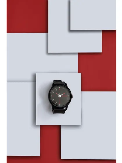 A graphic, top-down shot of a black watch against a geometric background of red and white squares. This minimalist and bold composition is perfect for modern brands targeting a design-conscious audience.