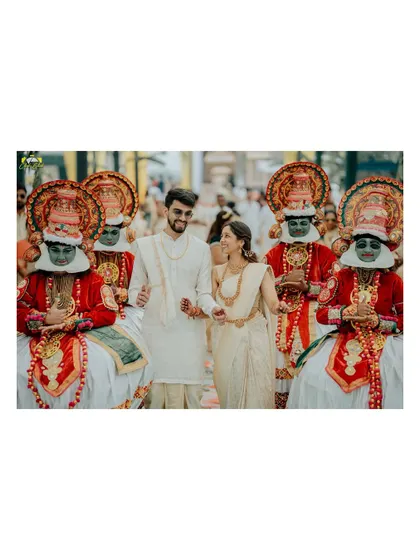 The couple makes a grand entrance, flanked by traditional Kathakali dancers. This is a powerful and colorful image that showcases the unique and memorable aspects of their wedding.