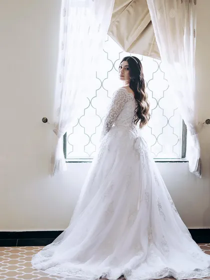 A classic bridal portrait by the window, using natural light to create a timeless and elegant photograph.