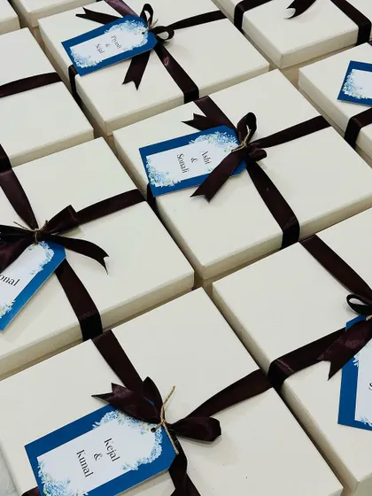 A neat arrangement of our personalized gift boxes, each tied with a beautiful ribbon and a custom name tag.