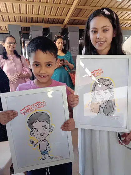 These siblings are all smiles with their framed caricatures. It's a unique way to capture their childhood personalities.