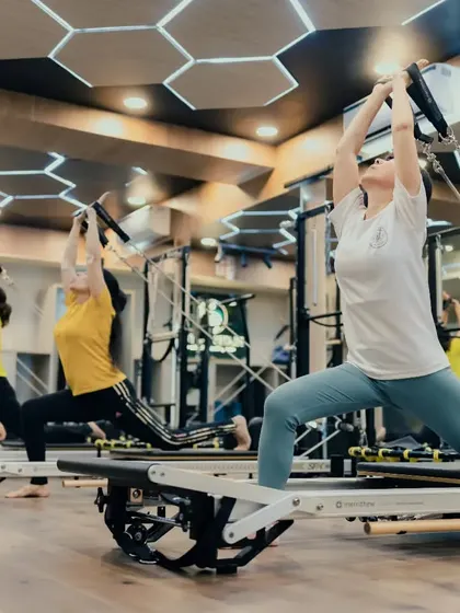 A synchronized group lunge sequence in action. This exercise not only strengthens the legs but also improves posture and coordination as everyone moves together on their Reformers.