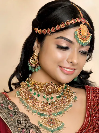 A smiling model showcases the elegance of our green Kundan jewellery. The set is designed to be grand yet comfortable to wear.