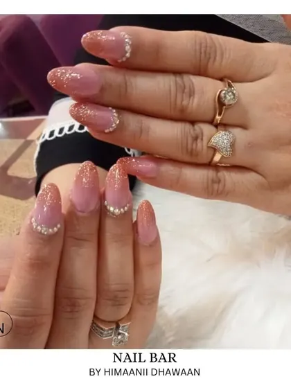 A beautiful ombré glitter design with a nude base fading into a sparkling tip, accented with small pearls.