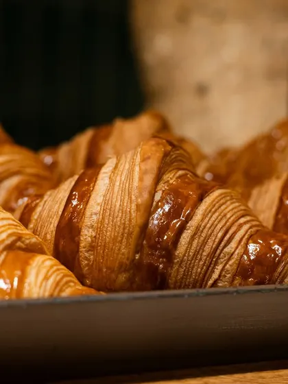 A tray of fresh, golden croissants in Paris. This image is perfect for a bakery, conveying authenticity and high quality.