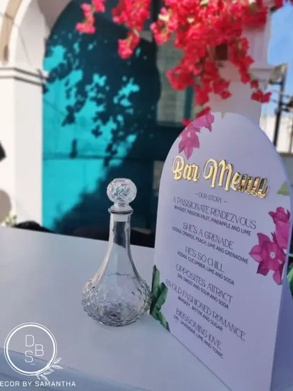A closer look at the custom bar menu, designed with a bougainvillea motif and gold lettering. The cocktail names told the couple's love story.