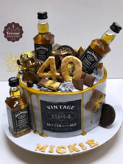 A Jack Daniel's themed cake for a 40th birthday, overloaded with chocolates and real miniature whiskey bottles. This is a dream cake for any whiskey enthusiast.