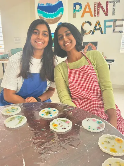 Two sisters proudly show off the beautiful pressed flower resin coasters they made together.