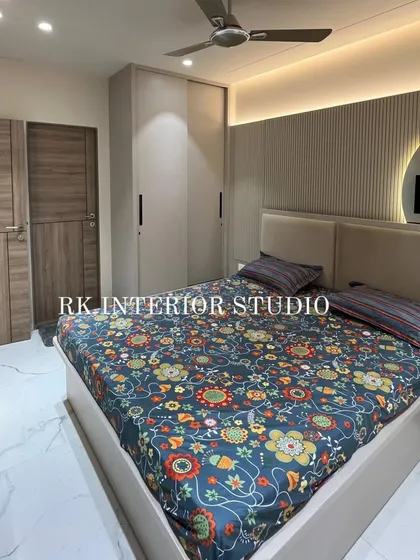 This angle showcases the full bedroom layout, including the bed, wardrobe, and TV unit. The consistent color and material palette creates a cohesive and calming space.