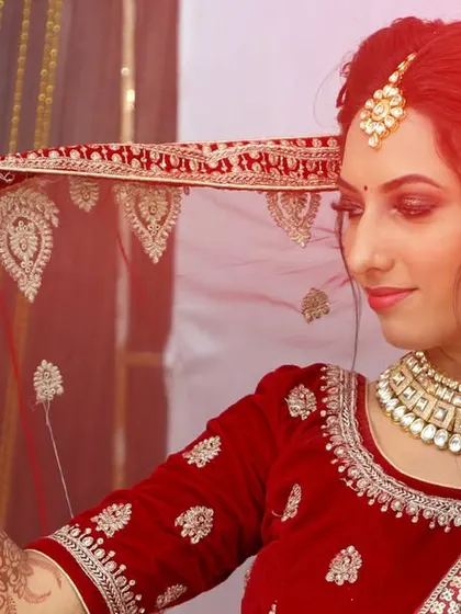 A beautifully lit portrait of a bride holding her embroidered veil.