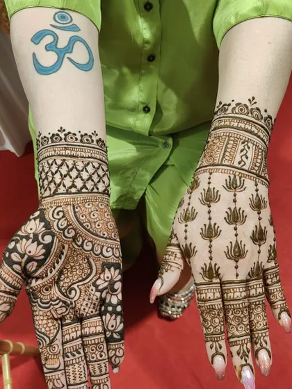 A beautiful example of two different styles for a client. One hand features a dense floral and paisley pattern, while the other has a neat grid of lotus motifs.
