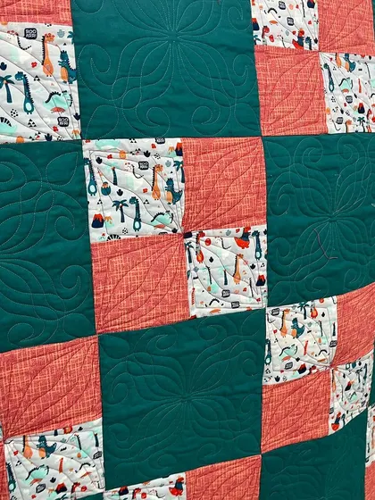 Another detail shot of the dinosaur-themed four-patch quilt.
