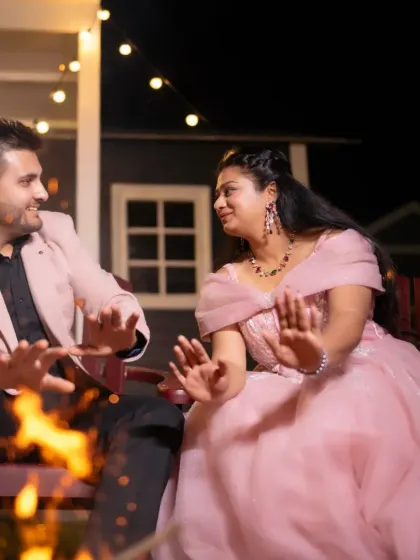 A fun and candid moment by the fire. The bride's soft pink ball gown looks magical under the warm lights, creating a cozy and romantic pre-wedding memory.