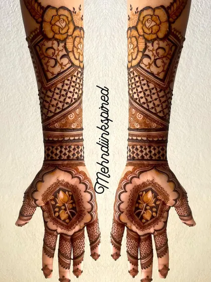 Symmetrical beauty for a bride's big day. This design features a central lotus on each palm, with arms covered in geometric patterns and bold rose motifs at the top.