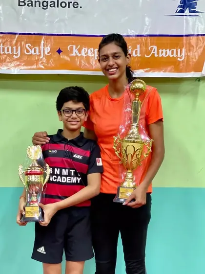 State Champions Reyansh J (U-11) and Maria Rony (Women's Singles) celebrating their victories together.