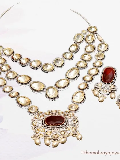 An elegant illustration of a multi-layered Polki necklace with a large ruby-colored central stone, showcasing the design and detail of our pieces.