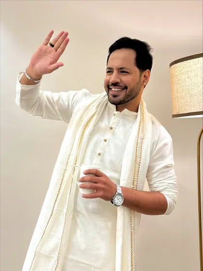 A friendly wave while holding a cup of chai. This shows my relaxed, behind-the-scenes personality.