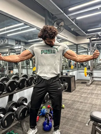 13 days to go. Posing in front of the dumbbell rack. The countdown continues, and the excitement builds.