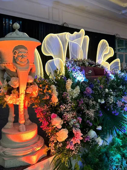 Another view of the unique reception stage, highlighting the glowing floral backdrop and the artistic props.