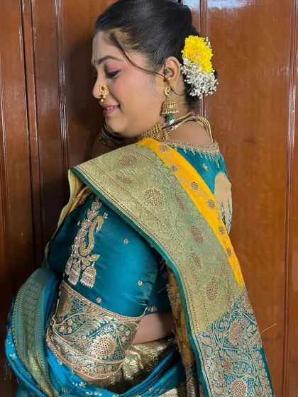 A beautiful shot showing the back of the blouse and the elegant bridal bun, a key part of the Maharashtrian look.