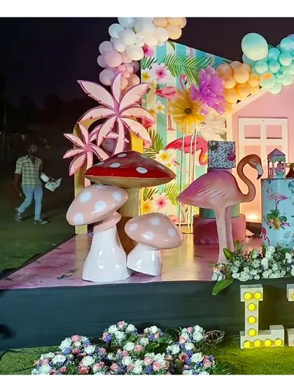 A closer look at the flamingo and mushroom props. These large, colorful elements are key to creating a vibrant and memorable tropical theme.